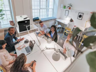 Business meeting in modern office with desktop printer in background