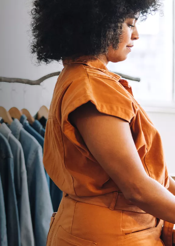 Female business owner using a laptop in her clothing store